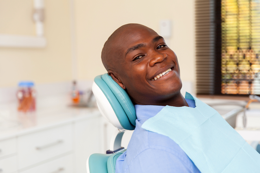 Black man smiles in a dental chair before his dental cleaning in Indian Plains