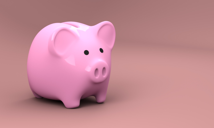 Pink plastic piggy bank for saving money against a darker pink background