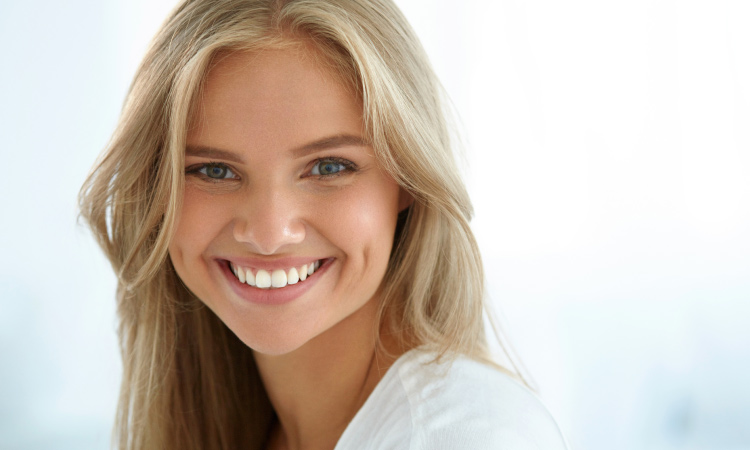 Blonde woman with a beautiful white smiles because it was cleaned using professional dental tools