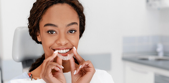 woman holding her clear aligners
