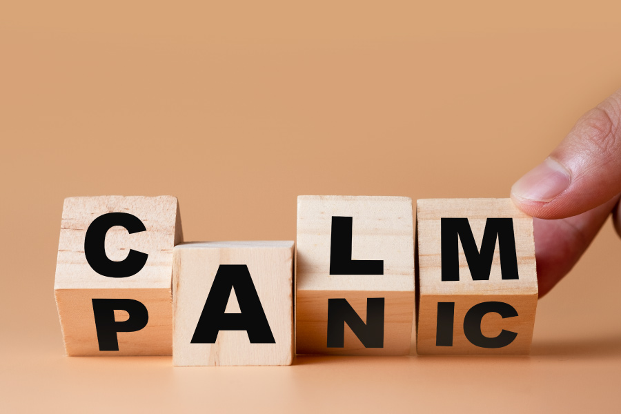 Wooden blocks being turned from PANIC to CALM by a finger