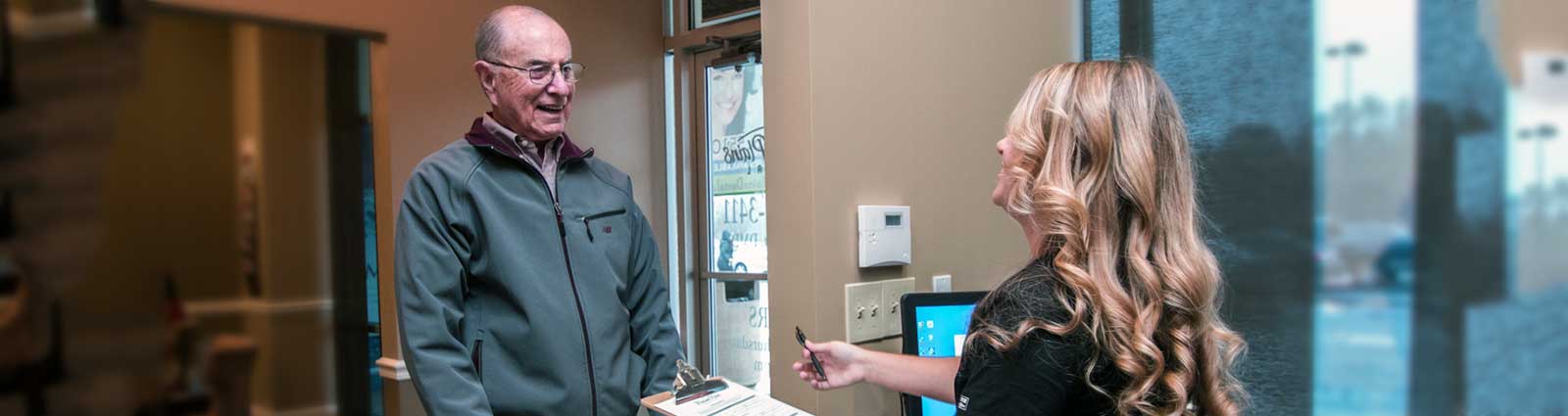 receptionist speaking with a patient