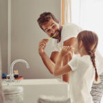 oral hygiene, dad and daughter brushing their teeth